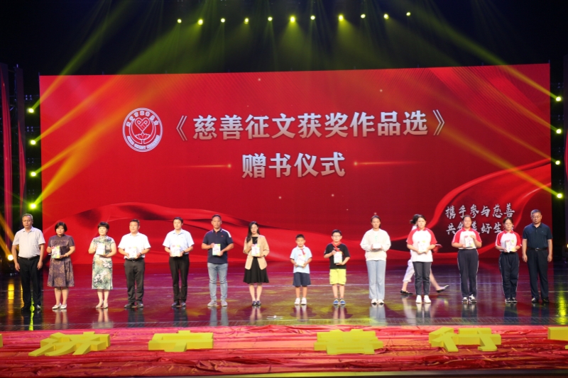 5 市民政局马国安局长，市慈善总会殷令喜秘书长为征文比赛获奖作品作者和优秀组织奖获奖单位代表赠书_副本.jpg